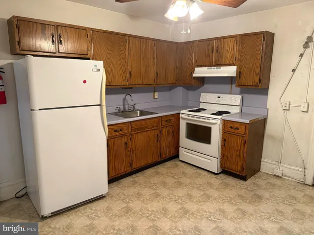 a kitchen with a refrigerator sink stove and cabinets