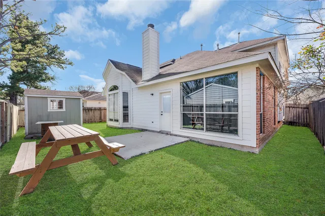 a backyard of a house with table and chairs