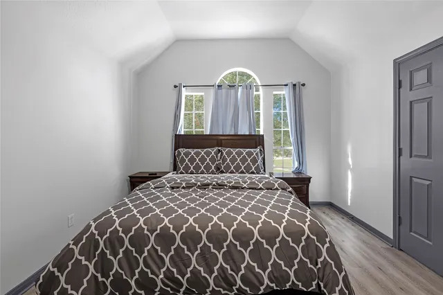 a bedroom with a bed and a lamp next to a window