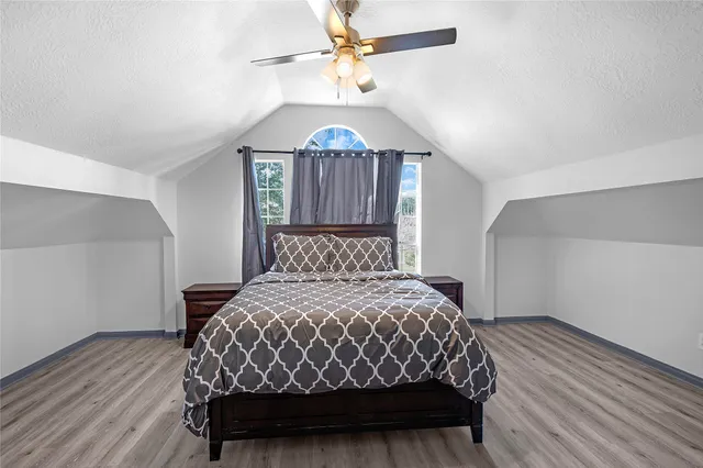 a bedroom with a bed mirror and a window