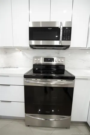 a stove top oven sitting inside of a kitchen