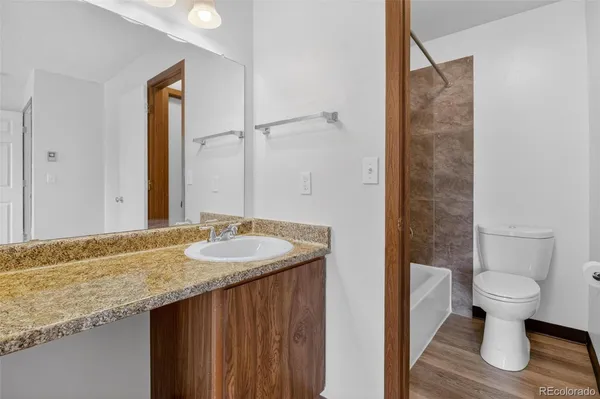 a bathroom with a granite countertop sink and a mirror