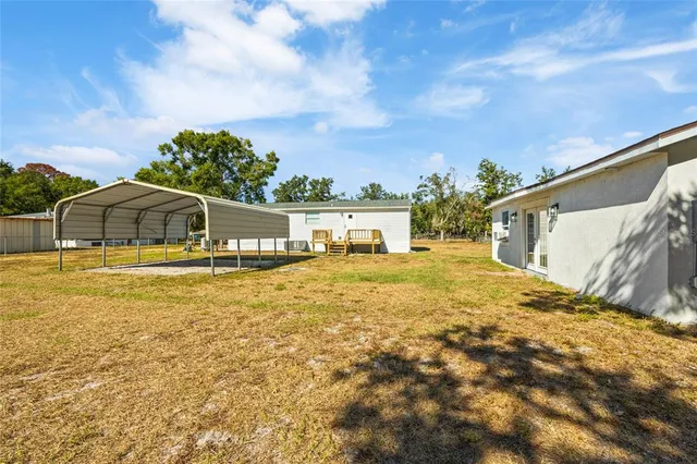 a house view with swimming pool and trees in the background
