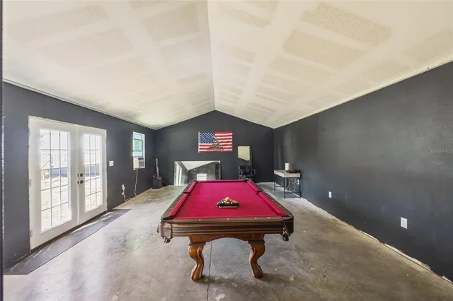 a room with pool table and windows
