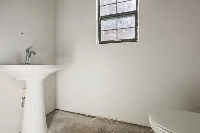 a bathroom with a sink window and toilet