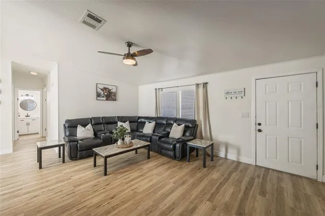a living room with furniture and a wooden floor