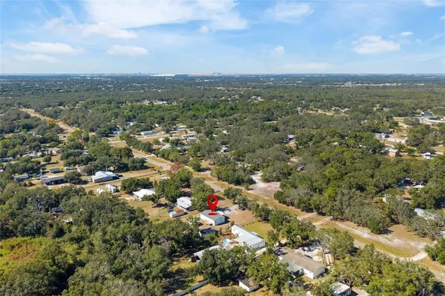 an aerial view of residential houses with city and green space