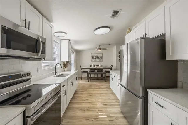 a large kitchen with a large window and stainless steel appliances