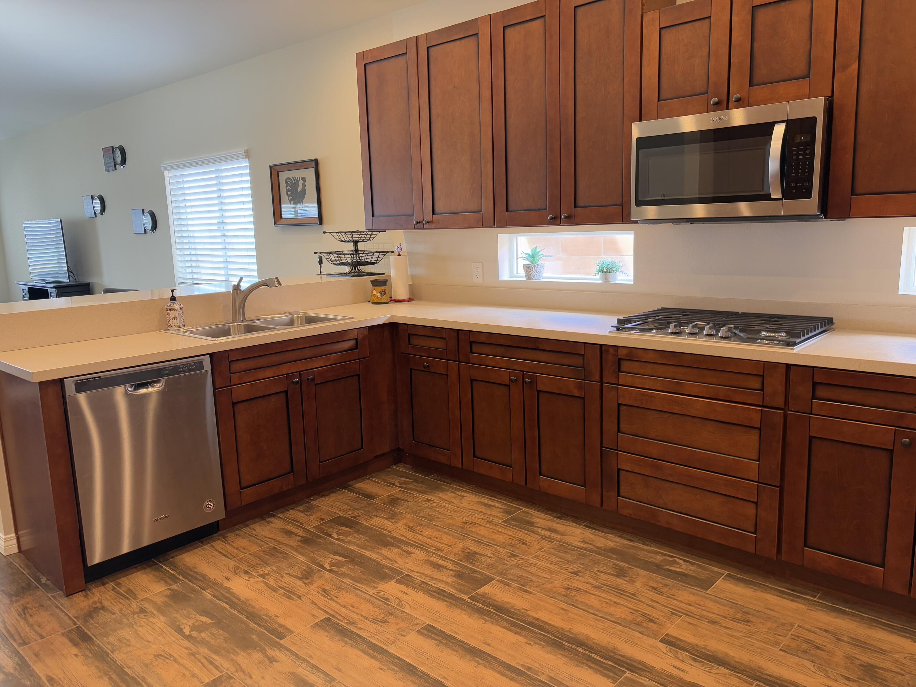 2674 Colorado River Road Blythe, CA 92225 - Photo 26 of 73 a kitchen with stainless steel appliances granite countertop wooden cabinets a stove a sink and dishwasher with wooden floor