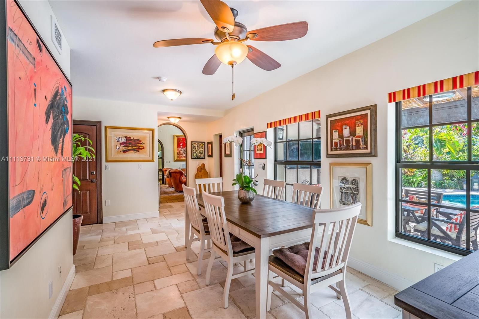 4444 Alton Road Miami Beach, FL 33140 - Photo 22 of 55 a dining room with furniture a flat screen tv and a floor to ceiling window