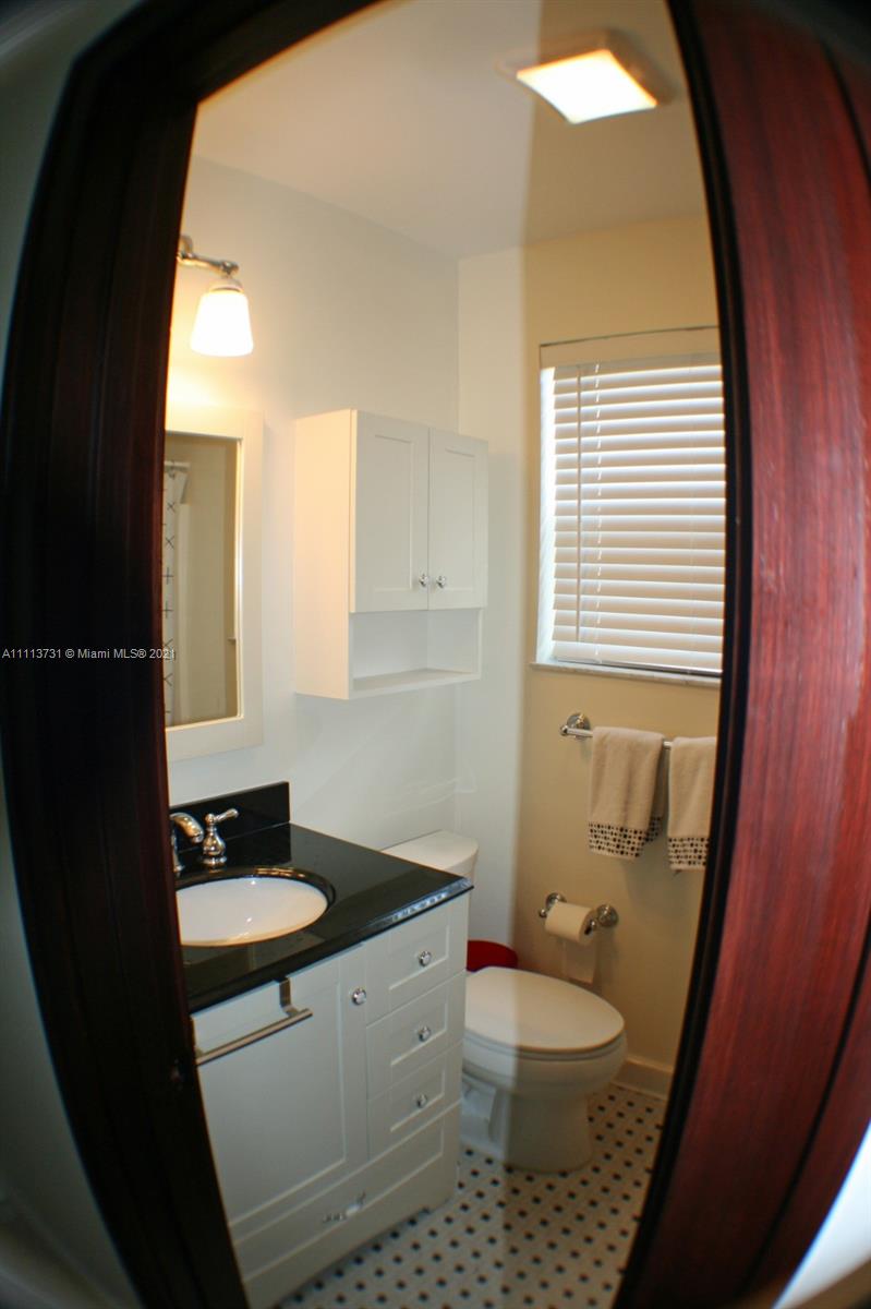 4444 Alton Road Miami Beach, FL 33140 - Photo 50 of 55 a bathroom with a sink a toilet a mirror and vanity