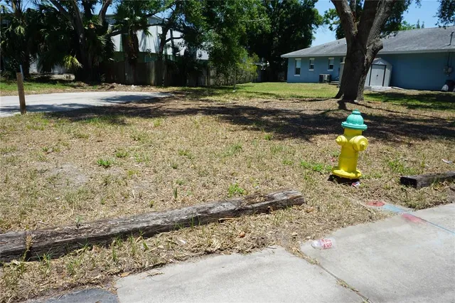 a view of a yard with wooden fence