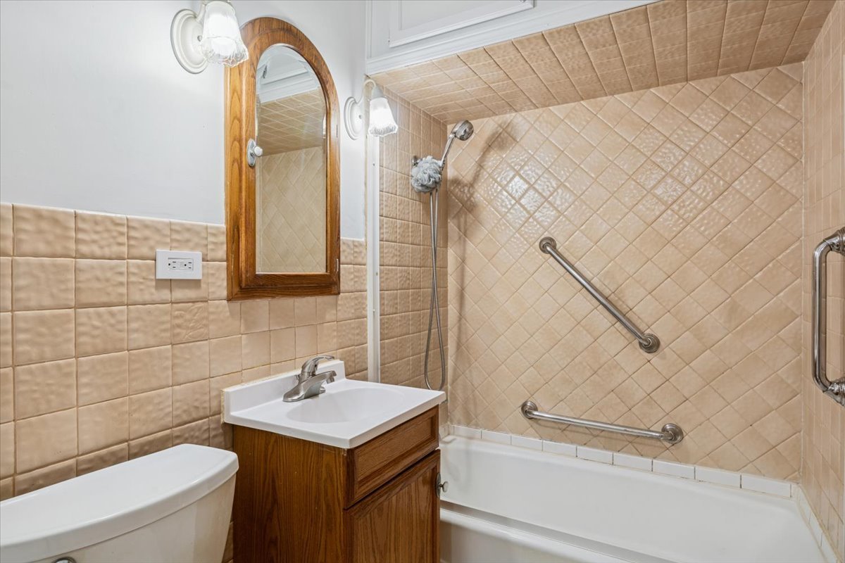 7841 44th Street Lyons, IL 60534 - Photo 13 of 23 a bathroom with a sink a toilet and a mirror