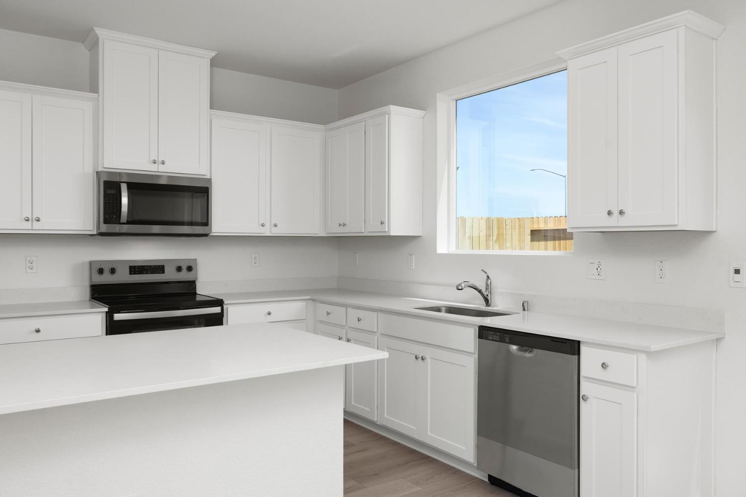 820 Chatham Lane Patterson, CA 95363 - Photo 6 of 19 a kitchen with stainless steel appliances granite countertop white cabinets sink and window
