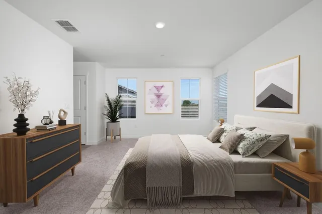 a bedroom with a bed and a lamp on dresser