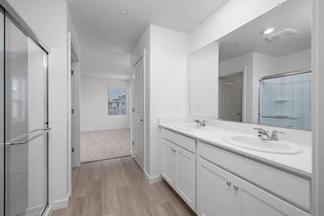 a bathroom with a double vanity sink mirror and shower
