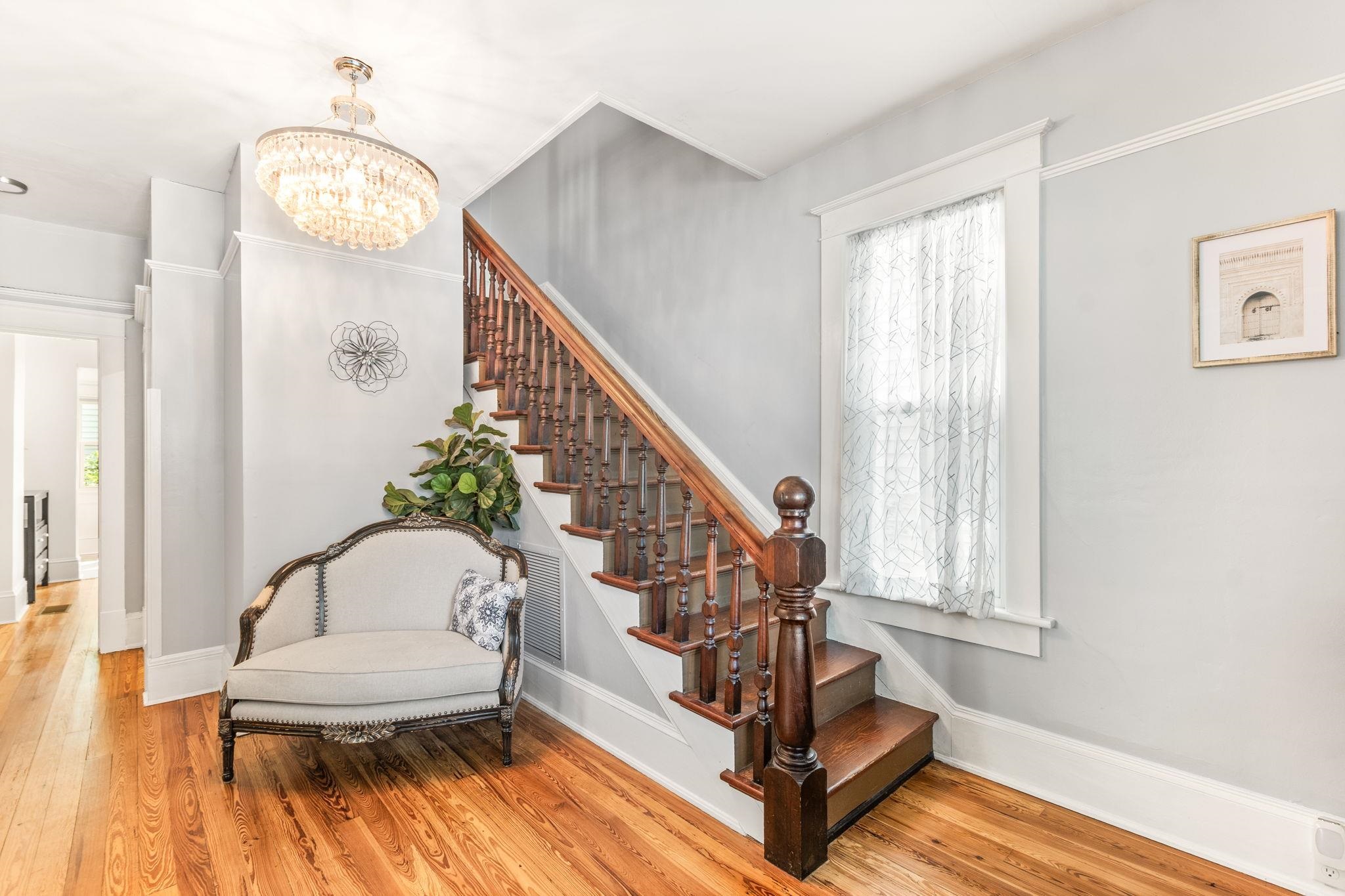 21 Saragossa Street St. Augustine, FL 32084 - Photo 1 of 66 Staircase with wood finished floors and a chandelier