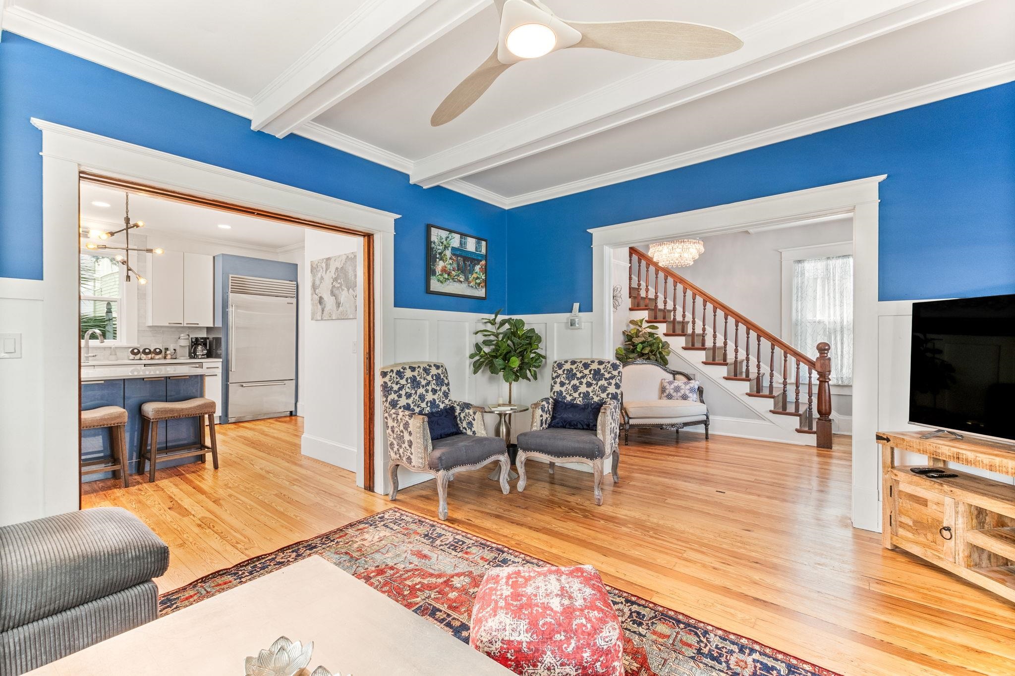 21 Saragossa Street St. Augustine, FL 32084 - Photo 13 of 66 Living room with hanging lights, light wood-style flooring, a wainscoted wall, ceiling fan, and beamed ceiling
