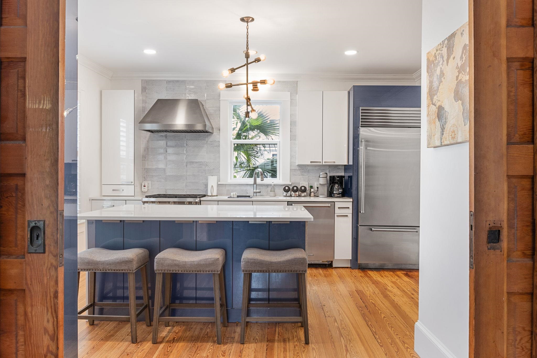 21 Saragossa Street St. Augustine, FL 32084 - Photo 17 of 66 Dual tone kitchen featuring dual tone cabinetry, ornamental molding, stainless steel appliances, decorative backsplash, and light wood-type flooring