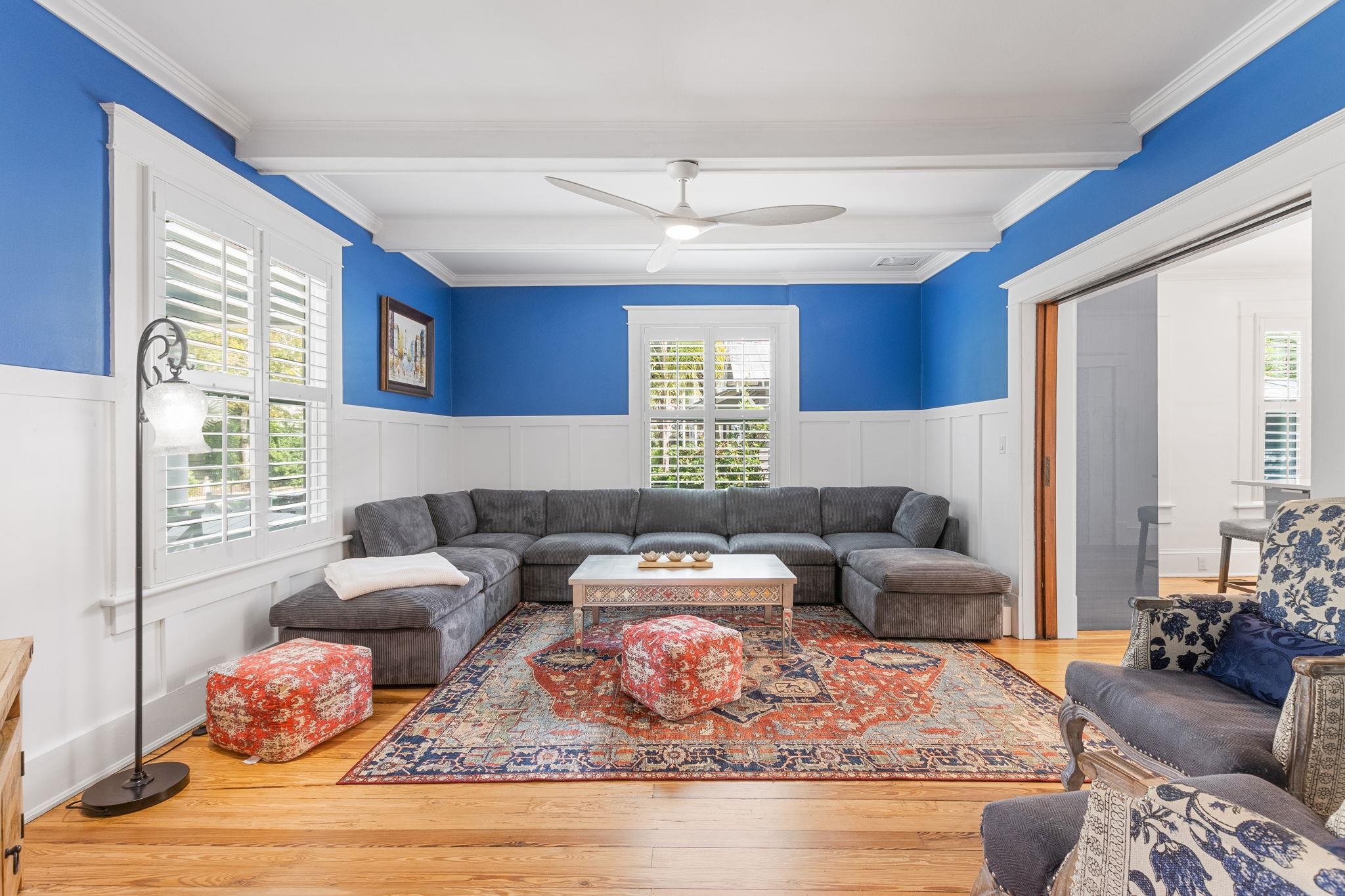 21 Saragossa Street St. Augustine, FL 32084 - Photo 2 of 66 Living area featuring ceiling fan, light wood-style flooring, a wainscoted wall, a decorative wall, and ornamental molding