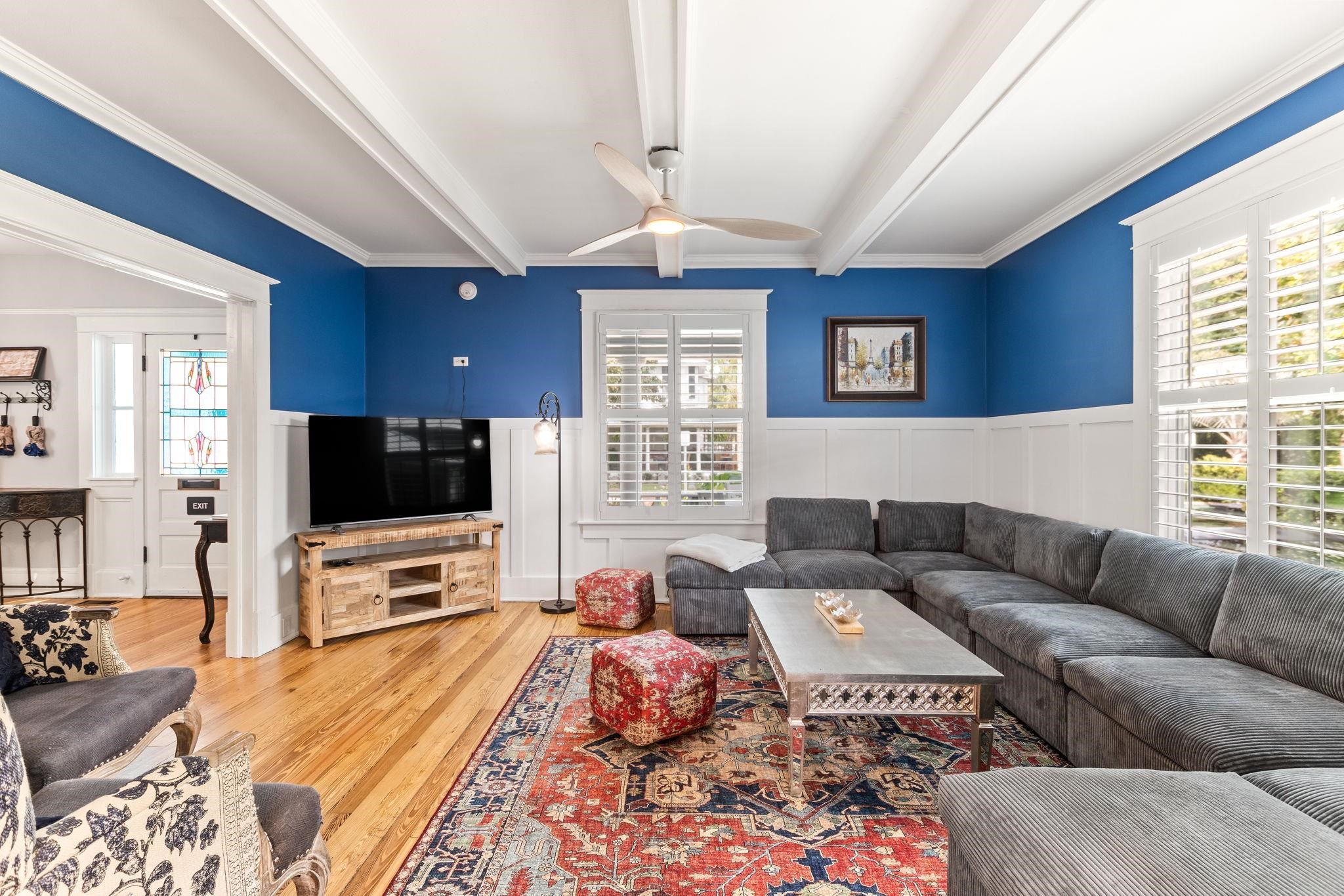 21 Saragossa Street St. Augustine, FL 32084 - Photo 2 of 66 Living area featuring wainscoting, a ceiling fan, crown molding, plenty of natural light, and hardwood / wood-style flooring