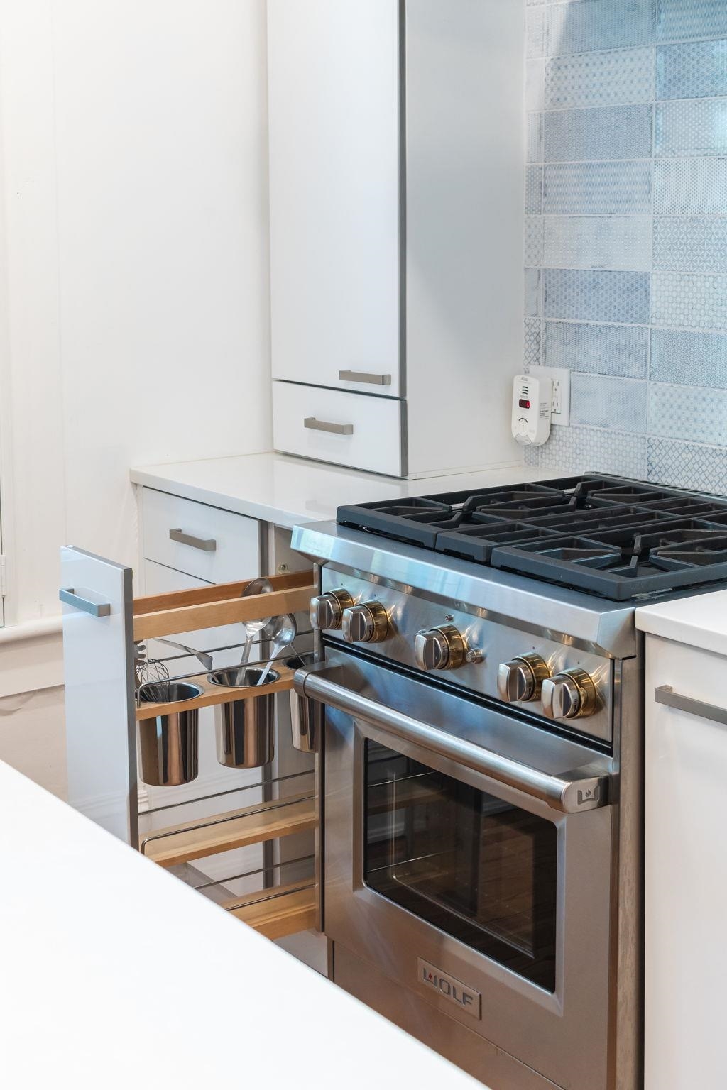 21 Saragossa Street St. Augustine, FL 32084 - Photo 23 of 66 Kitchen with premium range, white cabinets, light stone counters, and decorative backsplash