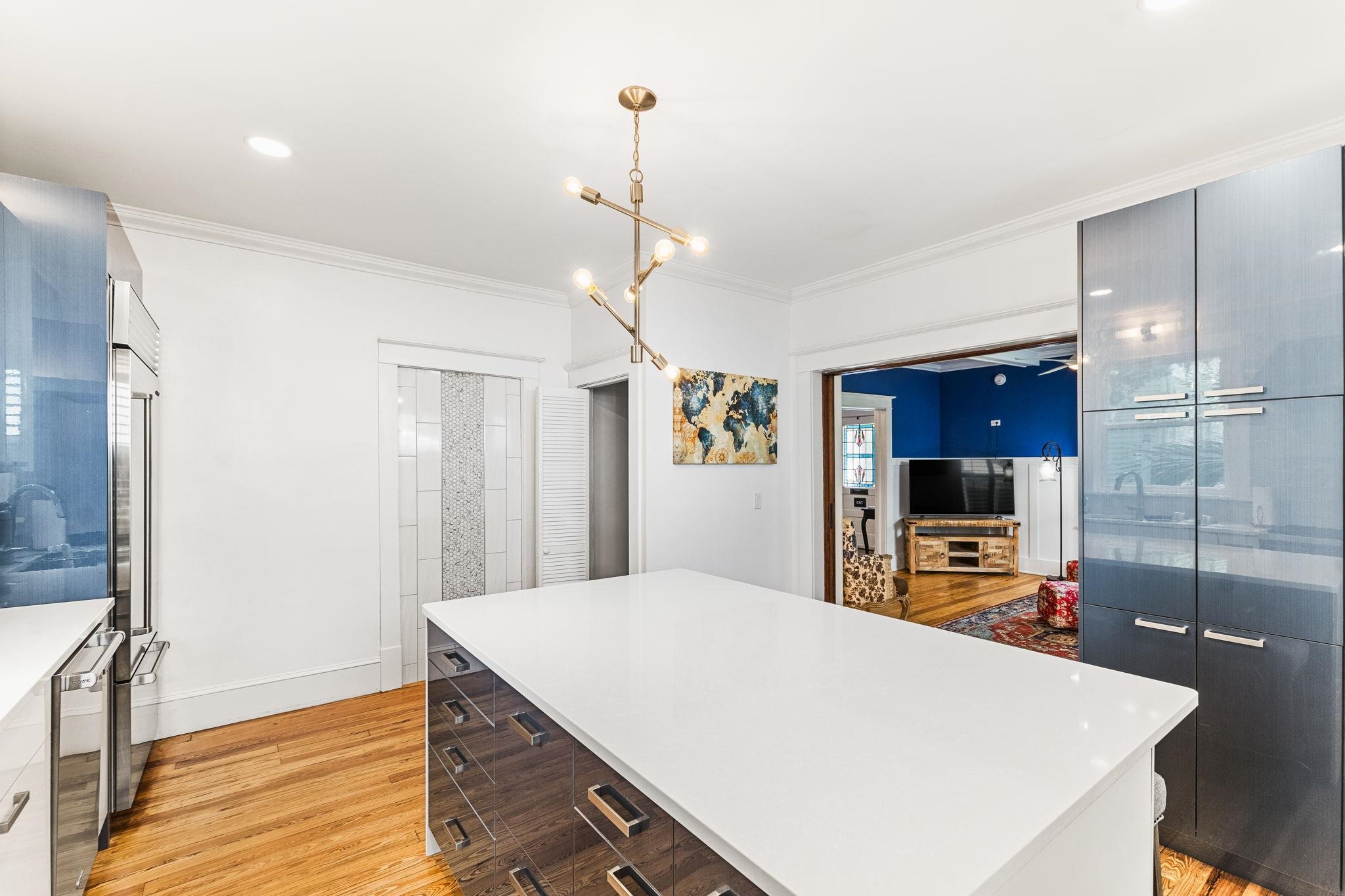 21 Saragossa Street St. Augustine, FL 32084 - Photo 25 of 66 Kitchen featuring modern cabinets, light wood finished floors, a kitchen island, stainless steel appliances, and ornamental molding