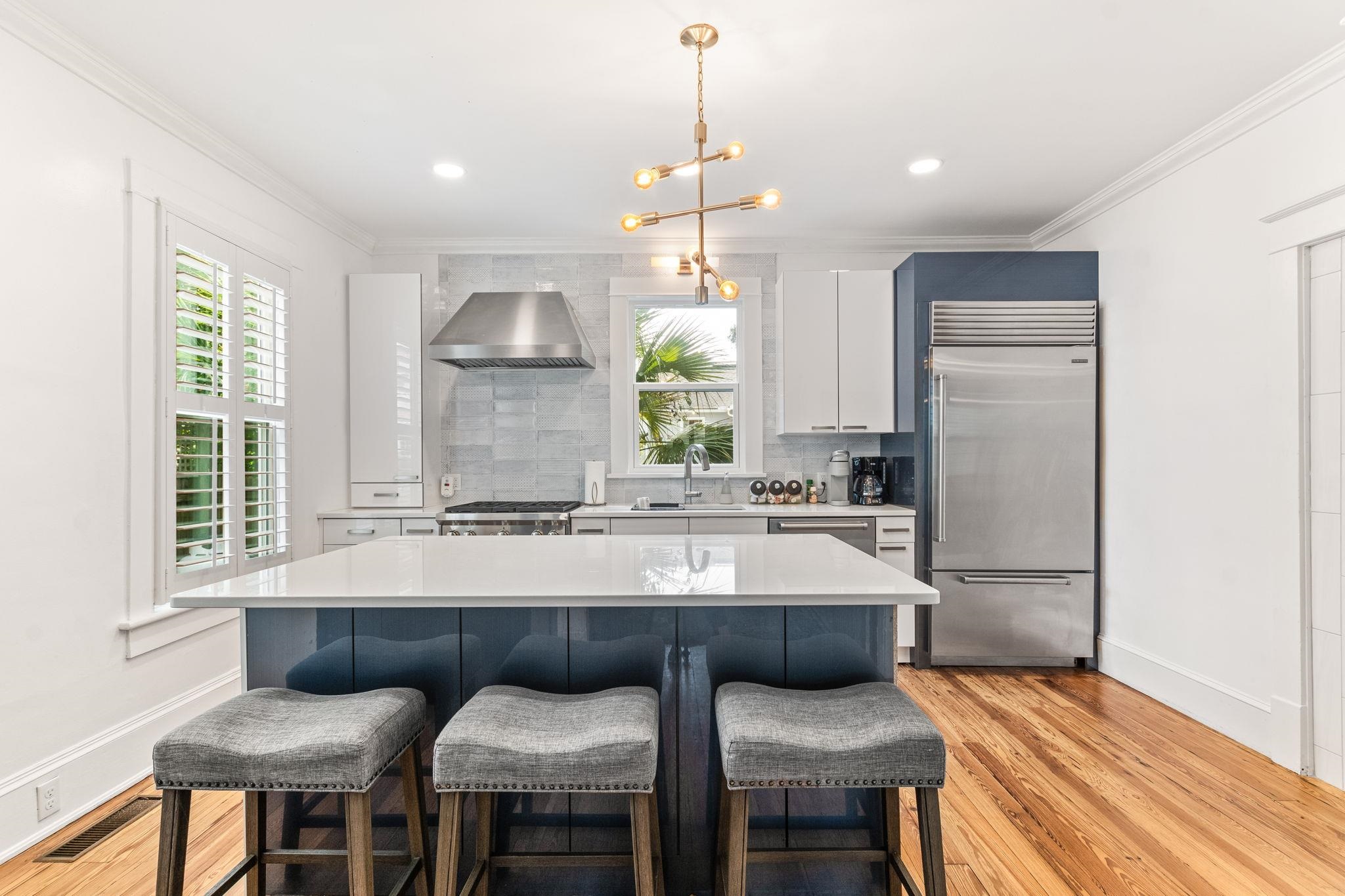 21 Saragossa Street St. Augustine, FL 32084 - Photo 3 of 66 Kitchen with two tone color scheme, stainless steel appliances, a kitchen island, a kitchen breakfast bar, and backsplash