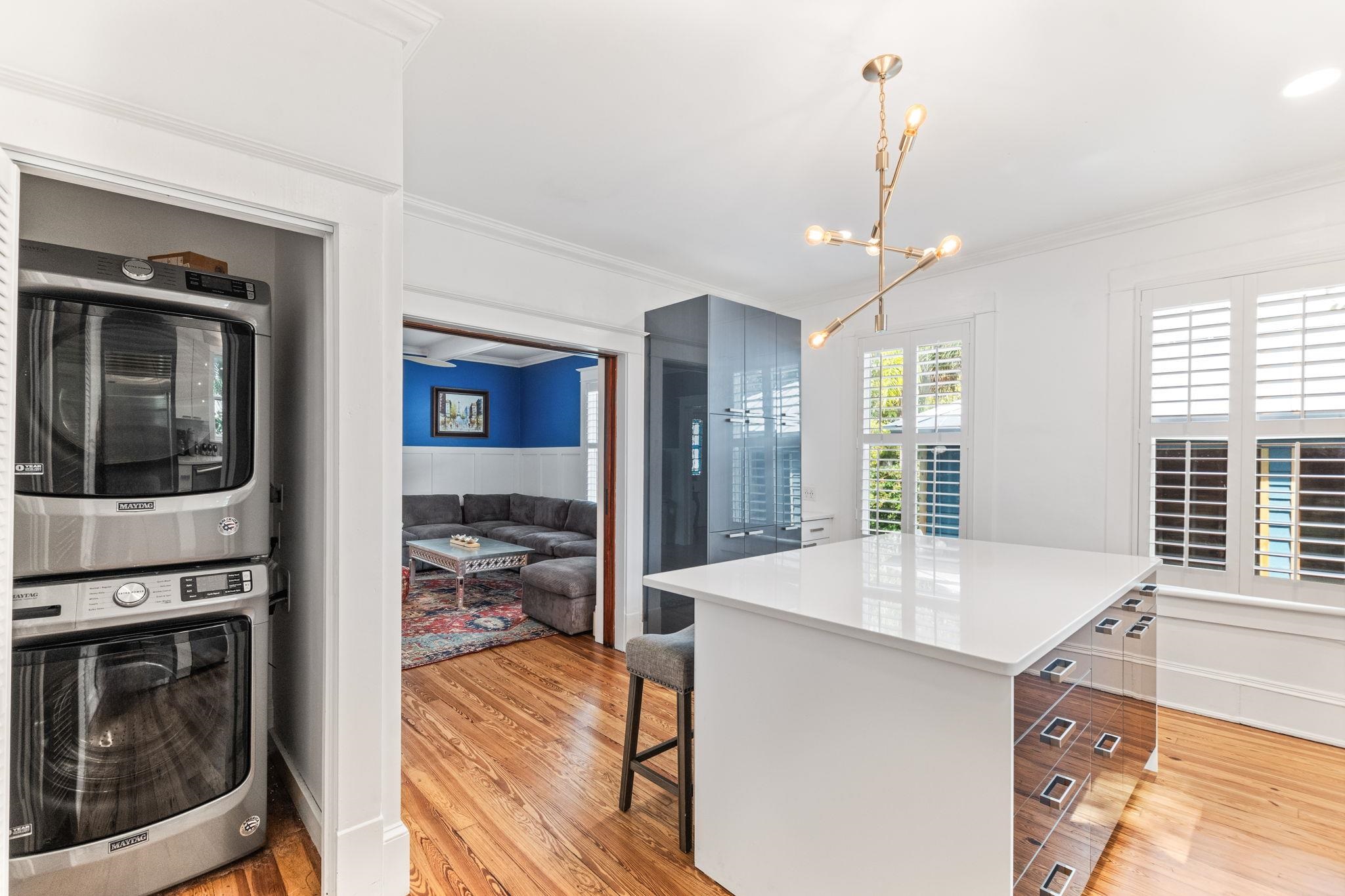 21 Saragossa Street St. Augustine, FL 32084 - Photo 33 of 66 Kitchen with a kitchen island, a kitchen breakfast bar, stacked washer and clothes dryer, modern cabinets, and light wood-style floors