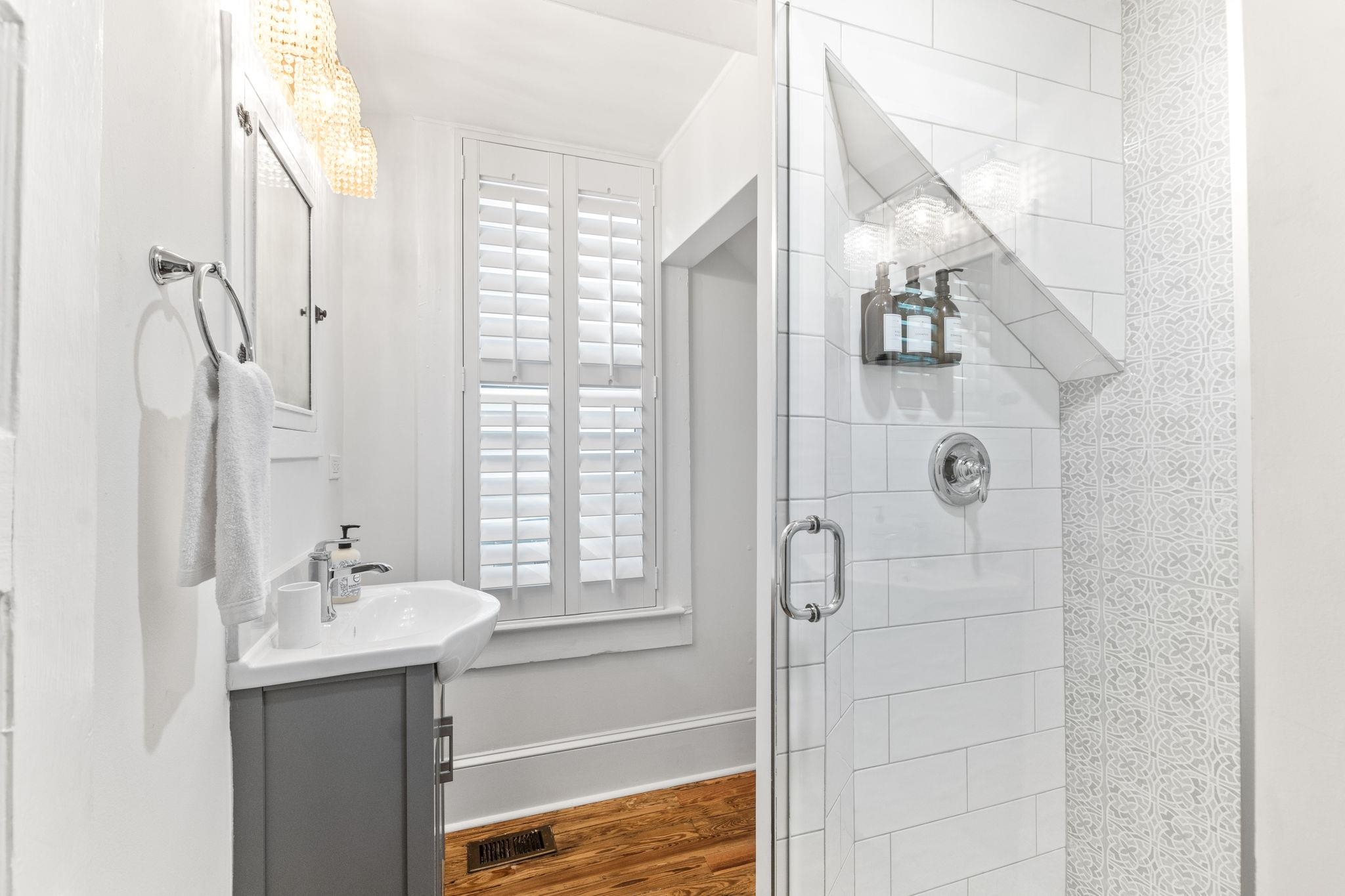 21 Saragossa Street St. Augustine, FL 32084 - Photo 40 of 66 Bathroom featuring a shower stall, vanity, and wood finished floors