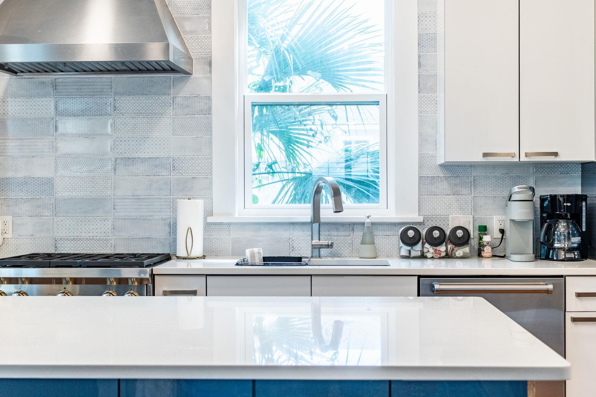 21 Saragossa Street St. Augustine, FL 32084 - Photo 4 of 66 Kitchen with stainless steel appliances, white cabinetry, decorative backsplash, and light stone countertops