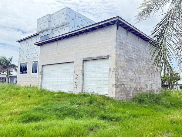a brick house with green field in front of it