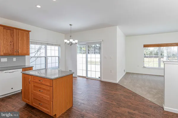 a kitchen with granite countertop wooden cabinets and a wooden floor