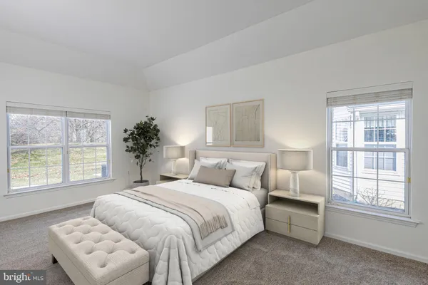 a bedroom with a bed and a large window