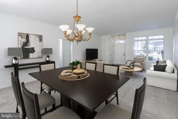 a view of a dining room with furniture a chandelier and large windows