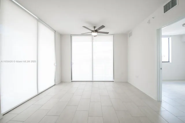 an empty room with fan and windows