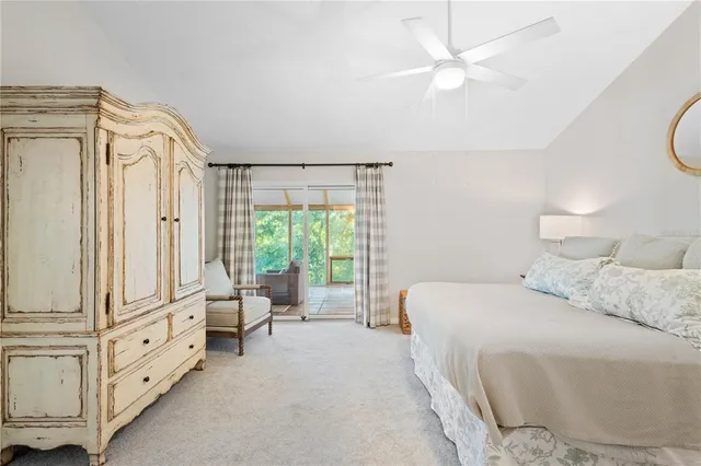 a spacious bedroom with a bed a couch and a chandelier