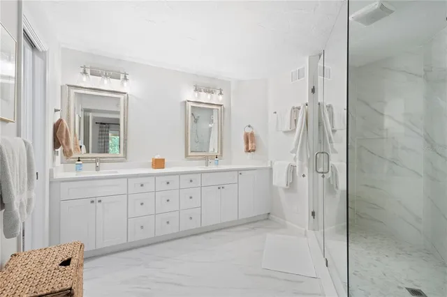 a spacious bathroom with double vanity and a mirror