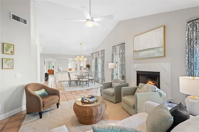 a living room with furniture a fireplace and a chandelier
