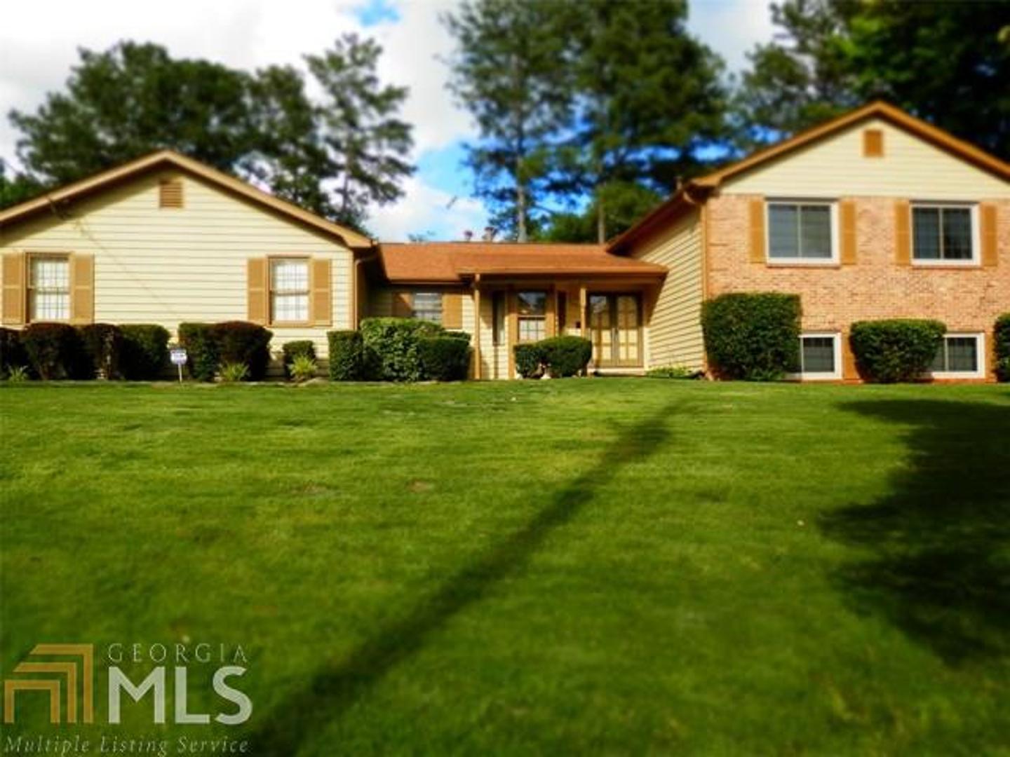 3378 Tarragon Drive, Unit 7 Decatur, GA 30034 - Photo 1 of 1 a view of a yard in front of a house with plants and large tree