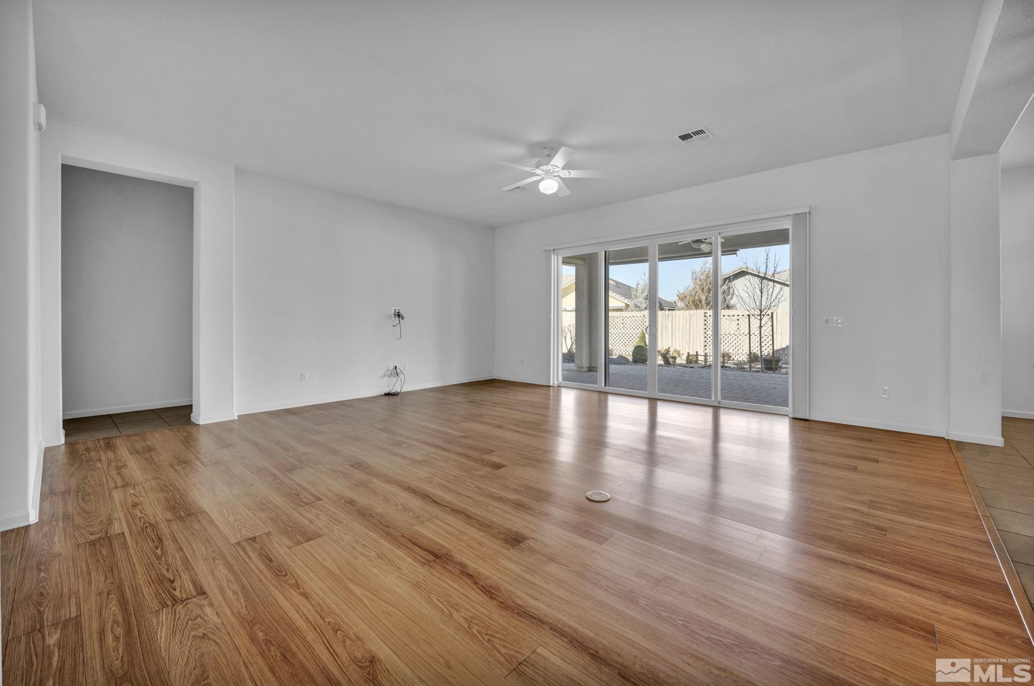 9825 Hafflinger Lane Reno, NV 89521 - Photo 14 of 39 a view of an empty room with wooden floor and a window