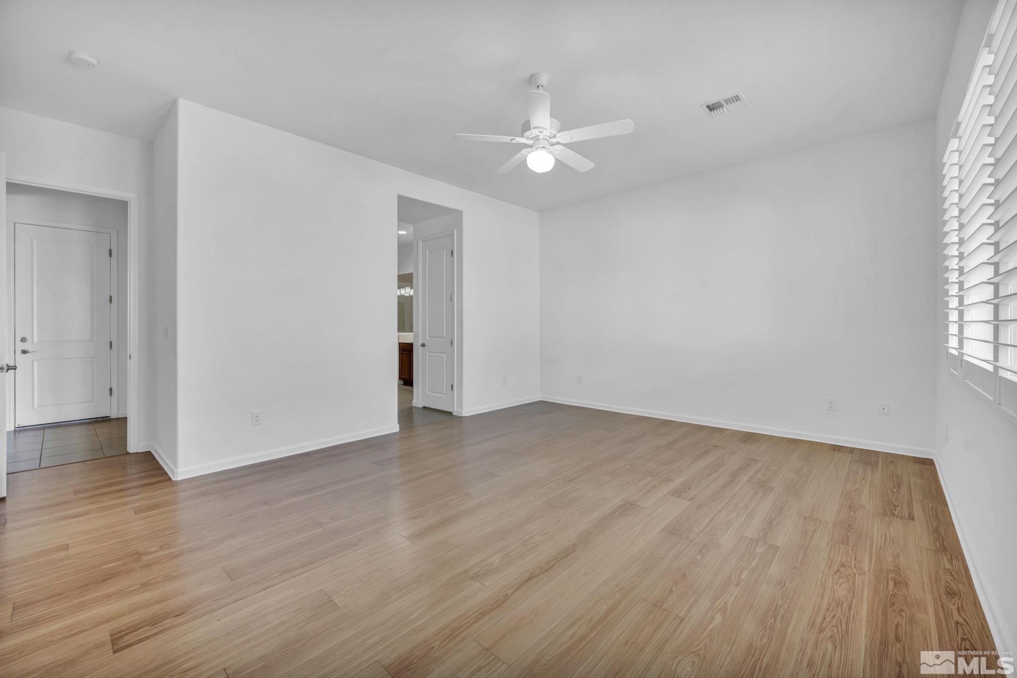 9825 Hafflinger Lane Reno, NV 89521 - Photo 17 of 39 a view of an empty room with wooden floor and a window