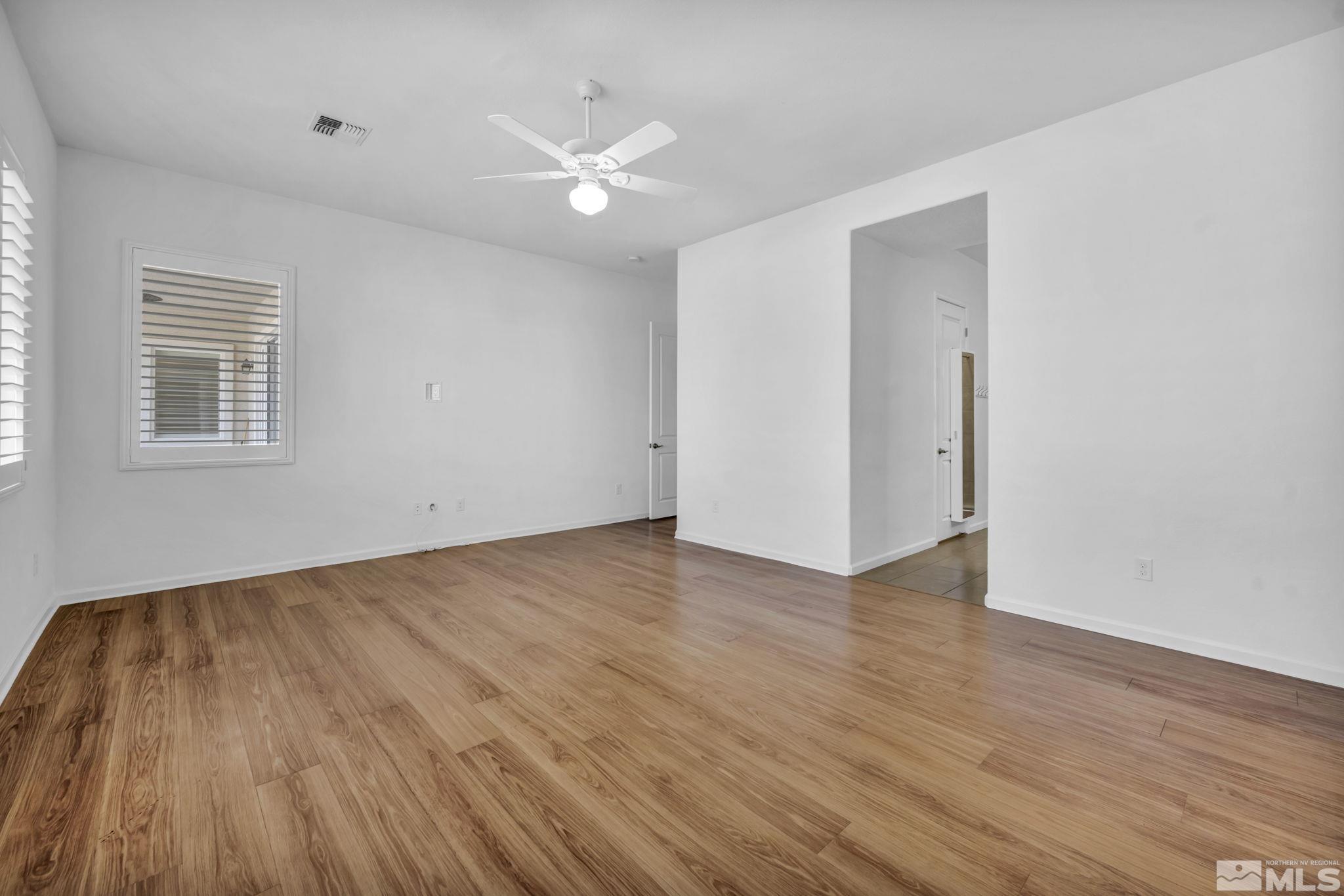 9825 Hafflinger Lane Reno, NV 89521 - Photo 18 of 39 a view of an empty room with wooden floor and a window