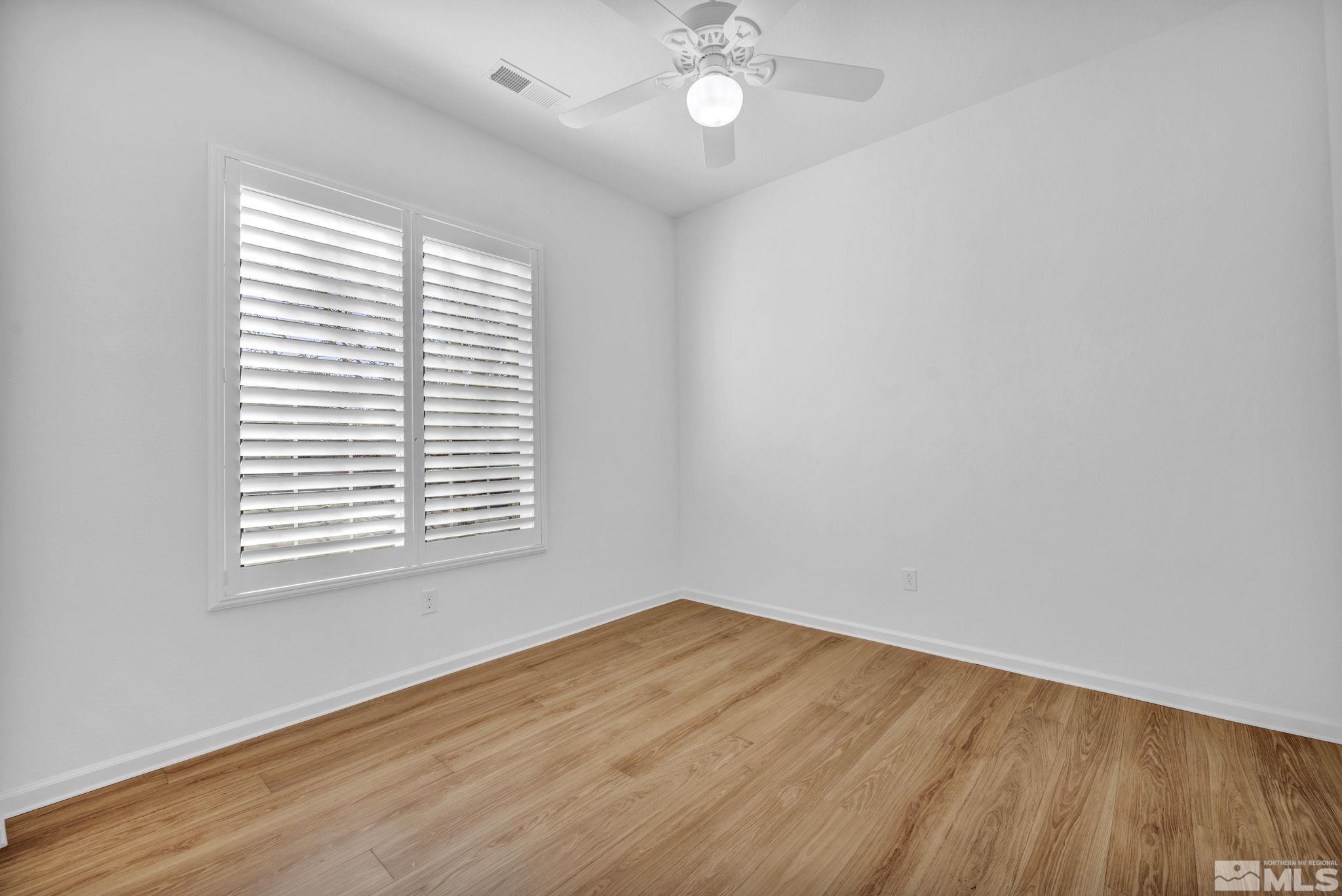 9825 Hafflinger Lane Reno, NV 89521 - Photo 21 of 39 an empty room with wooden floor and windows