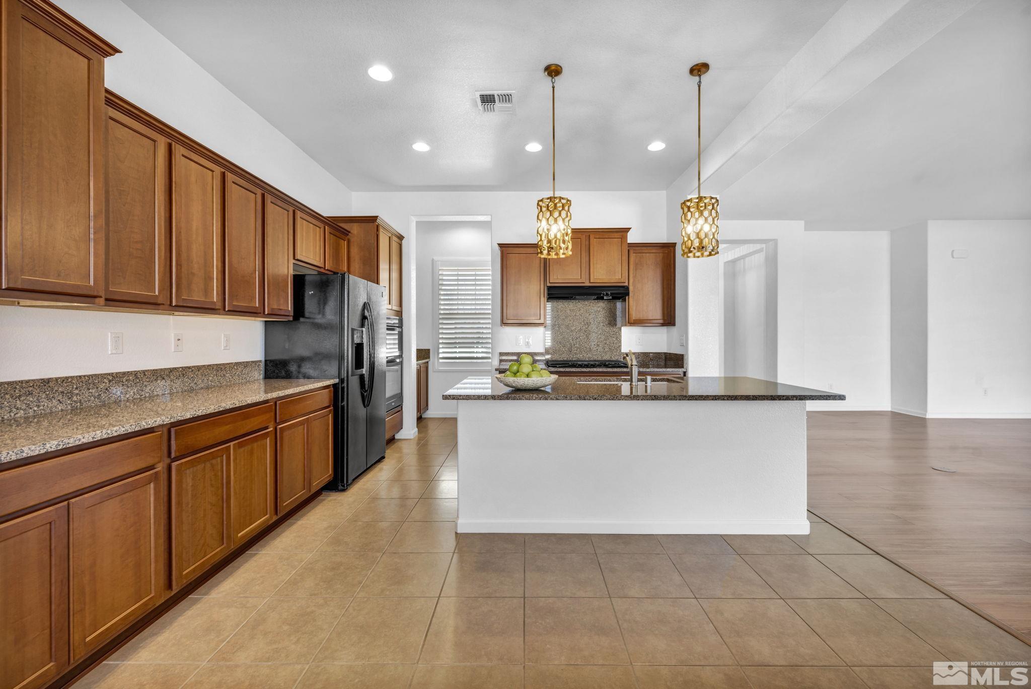 9825 Hafflinger Lane Reno, NV 89521 - Photo 7 of 39 a large kitchen with stainless steel appliances granite countertop a stove a sink and a refrigerator