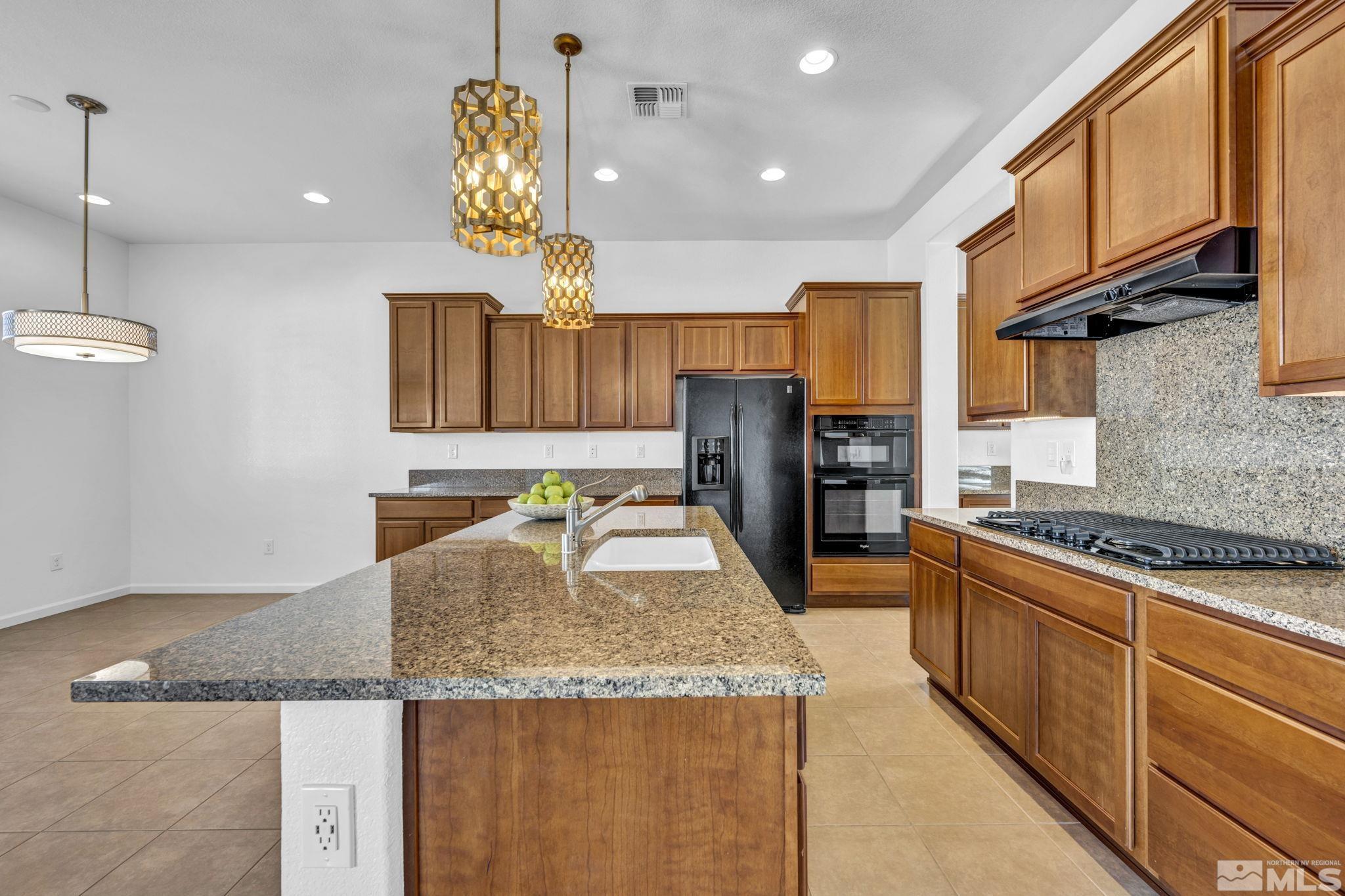 9825 Hafflinger Lane Reno, NV 89521 - Photo 9 of 39 a kitchen with stainless steel appliances granite countertop a sink and a refrigerator