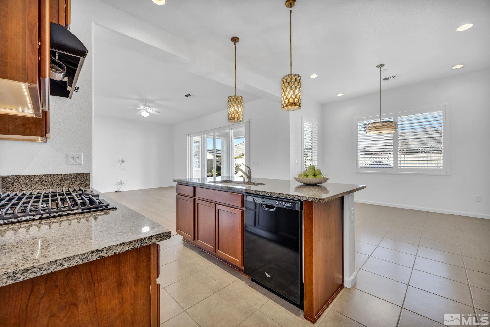 9825 Hafflinger Lane Reno, NV 89521 - Photo 10 of 39 a kitchen with stainless steel appliances granite countertop a stove a sink and a wooden floors