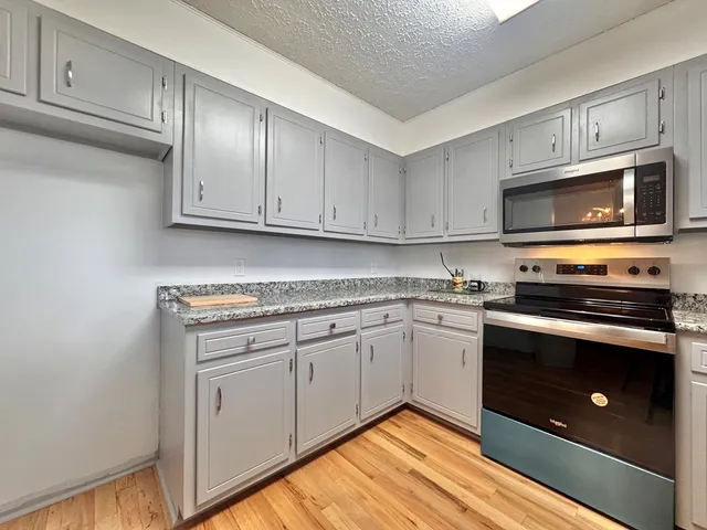 a kitchen with granite countertop cabinets stainless steel appliances and a sink