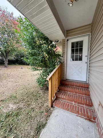 a backyard of a house with barbeque oven table and chairs