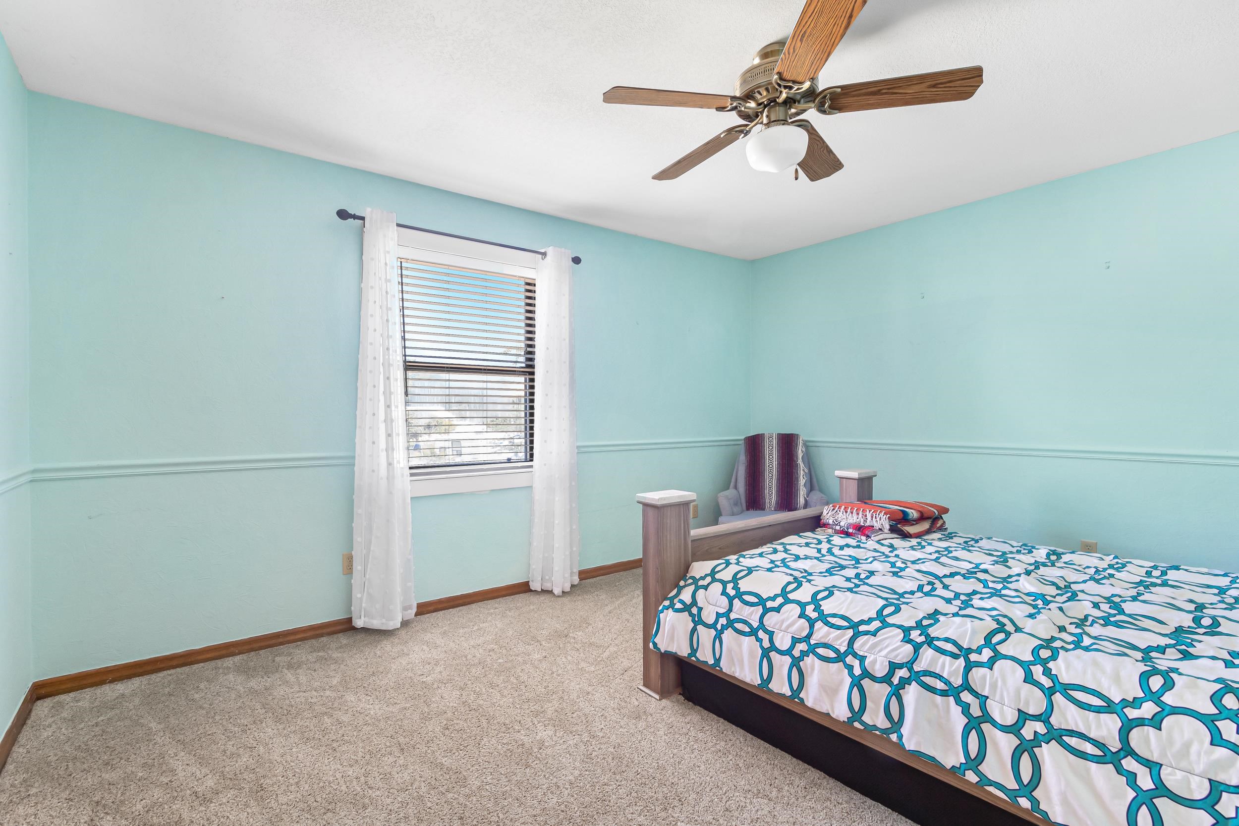 110 Harvard Road St. Augustine, FL 32086 - Photo 22 of 42 a bedroom with a large bed and a chandelier